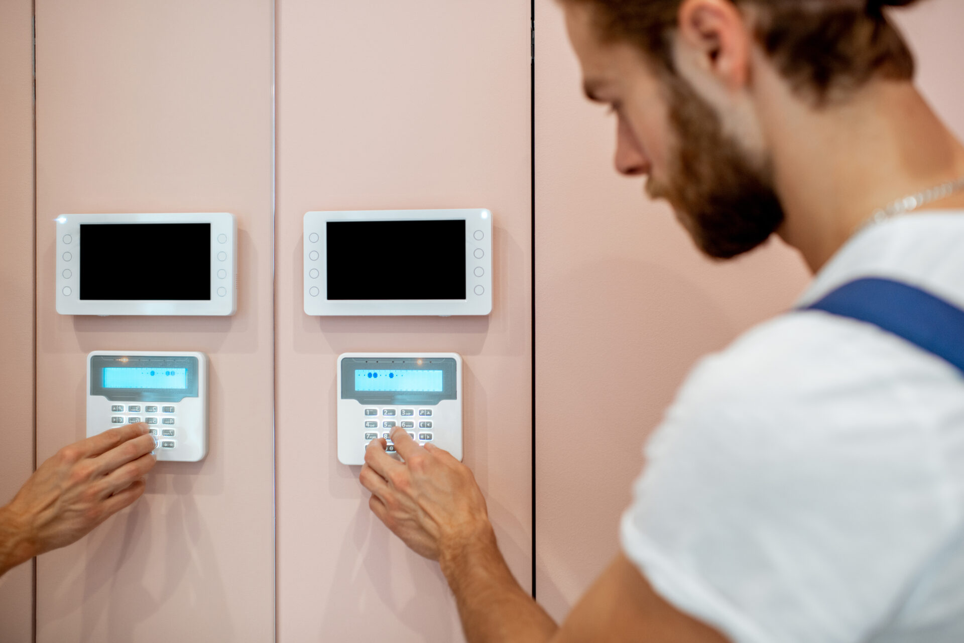 Workman setting up the alarm with keyboard near the entrance at home